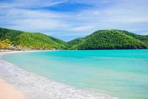 Idyllic tropical Carlisle bay beach with white sand, turquoise ocean water and blue sky at Antigua island photo