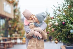 Adorable girls skating on ice rink outdoors in winter snow day photo