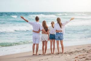 familia feliz de cuatro en la playa en vacaciones de verano foto