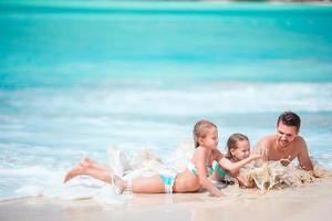 Father and little kids enjoying beach summer tropical vacation playing in shallow water photo