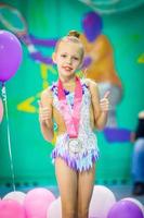 pequeña gimnasta encantadora con medalla después de la competencia de gimnasia rítmica foto