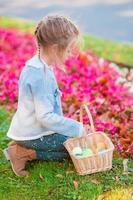 Girl looking for Easter eggs in the grass at Easter photo