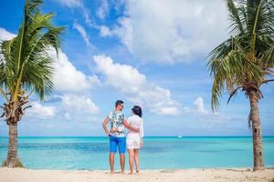 Young couple on white beach. Happy family on honeymoon vacation photo