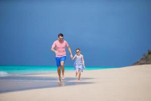 Family of father and sporty little girl having fun on the beach photo