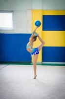 Beautiful little active gymnast girl with her performance on the carpet photo