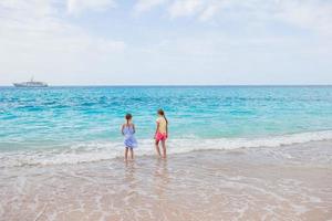 Adorable little girls have a lot of fun on the beach. photo