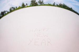 Happy New Year written in the white sand photo