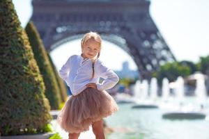 adorable niña pequeña en el fondo de parís la torre eiffel durante las vacaciones de verano foto