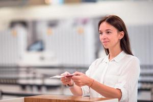 bella mujer con pasaportes y tarjetas de embarque en la recepción del aeropuerto foto