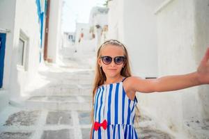 adorable niñita en la calle antigua del típico pueblo tradicional griego foto