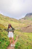 hermosa joven feliz en las montañas en el fondo de la niebla foto