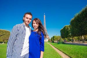 joven pareja feliz en el champ de mars en parís antecedentes la torre eiffel foto