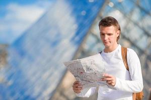 Young tourist man with map in european city outdoors photo