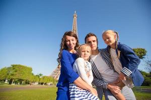 familia feliz con dos hijos en parís cerca de la torre eiffel. concepto de vacaciones, viajes y personas de verano francés. foto