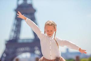 Adorable happy little girl in Paris background the Eiffel tower during summer vacation photo