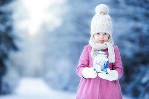 adorable niña con linterna y velas en invierno en navidad al aire libre foto