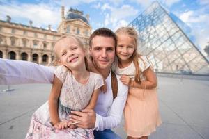 familia feliz con dos niños haciendo selfie en París foto