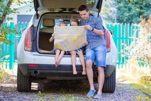 Father with kids sitting in car while traveling photo