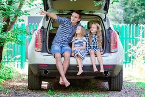 padre con hijos sentados en el auto mientras viaja foto