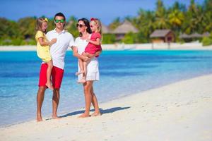 Happy beautiful family on white beach vacation photo