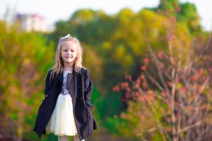 Adorable little girl outdoors at beautiful autumn day photo