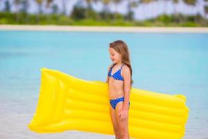 adorable niña con colchón inflable de aire durante las vacaciones en la playa foto