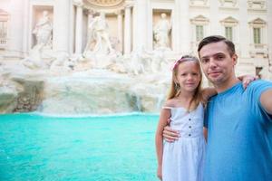 Young father and little girl making selfie in Coliseum, Rome, Italy. Family portrait at famous places in Europe photo