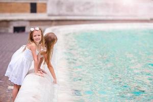 adorables niñas cerca de la fuente de trevi en roma. foto