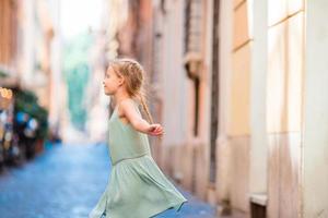 Adorable happy little girl outdoors in european city. Caucasian kid enjoy summer vacation in Rome photo