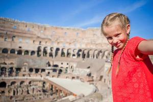 Little girl making selfie in Coliseum, Rome, Italy. Kid portrait at famous places in Europe photo