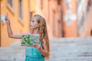 adorable niña con mapa turístico en calles romanas en italia. feliz niño toodler disfruta de vacaciones italianas en europa. foto