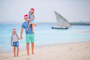 Father and daughters on Christmas vacation. Christmas family holidays on the beach photo