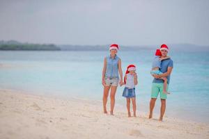 Happy family with two kids in Santa Hat on summer vacation photo