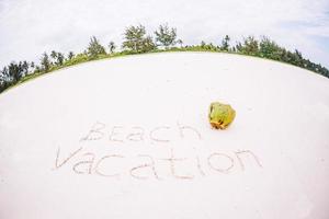 Dream written on sandy beach with soft ocean wave on background photo