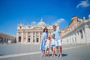 retrato de familia joven feliz en st. basílica de san pedro en ciudad del vaticano, roma. viajan padres e hijos en vacaciones europeas en italia. foto