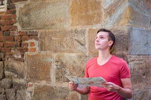 Man tourist with city map in old Europe street. photo