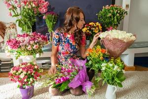 Beautiful young girl among a huge bouquet of roses photo