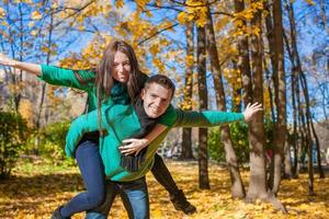 Happy couple having fun in autumn park on a sunny fall day photo