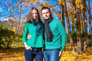 Portrait of Happy couple in autumn park on a sunny fall day photo