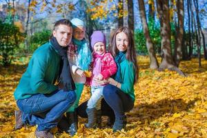 Young family with litlle girls in autumn park on sunny day photo