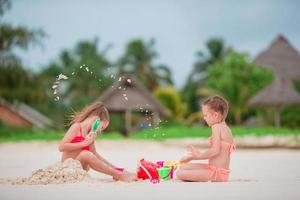 Little girls playing with beach toys during tropical vacation photo