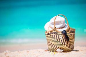 Beach accessories - straw bag, sunglasses, hat on the beach photo