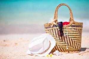 Beach accessories - straw bag, sunglasses, hat on the beach photo