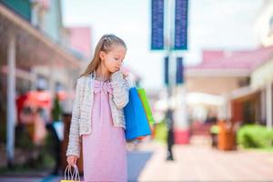 Portrait of little girl shopping outdoors photo