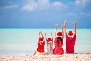 familia feliz con dos niños con sombrero de santa en vacaciones de verano foto