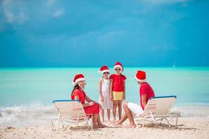 Happy family with two kids in Santa Hat on summer vacation photo