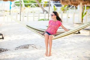 Young woman on tropical vacation relaxing in hammock photo