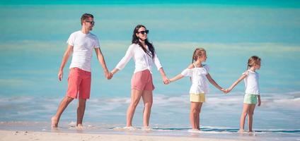 Happy family with kids walk on the beach at sunset photo