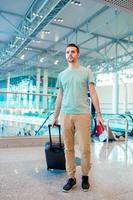 Young man in an airport lounge waiting for flight aircraft. photo