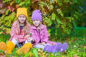 Adorable little girls at beautiful autumn day outdoors photo
